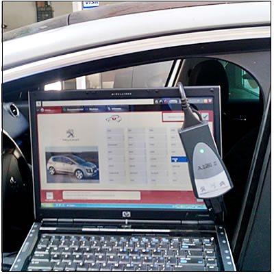 Notebook con el software de diagnóstico conectado a la toma OBD de un auto en el taller.