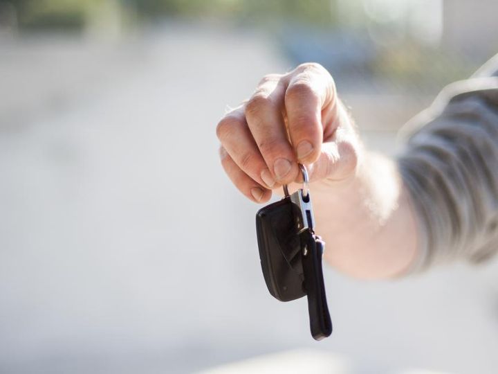 Una mano entrega la llave de un auto.